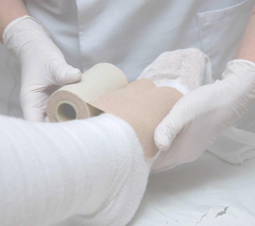 Applicazione di un bendaggio terapeutico su un paziente
